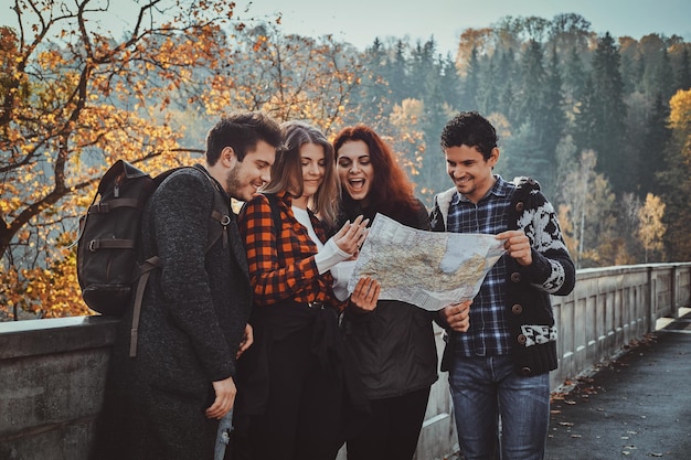 group young people are looking map where they are while walking autumn forest_613910 15159